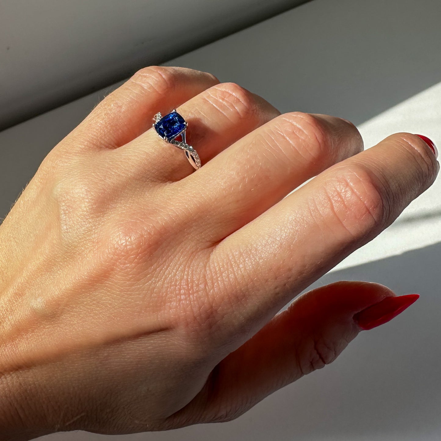 2 carat cushion cut sapphire and diamond love twist engagement ring on hand in platinum by Valentina Fine Jewellery HK. Global free shipping including USA, UK, Singapore and Australia. Bespoke engagement ring service