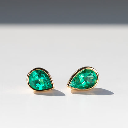 Colombian emerald bezel set green emerald stud earrings in 18k yellow gold by Valentina Fine Jewellery. Global free shipping including USA. Emerald jewellery is our speciality.