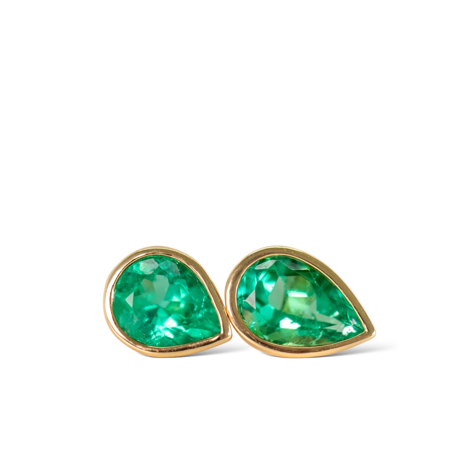 Colombian emerald bezel set green emerald stud earrings in 18k yellow gold by Valentina Fine Jewellery. Global free shipping including USA. Emerald jewellery is our speciality.